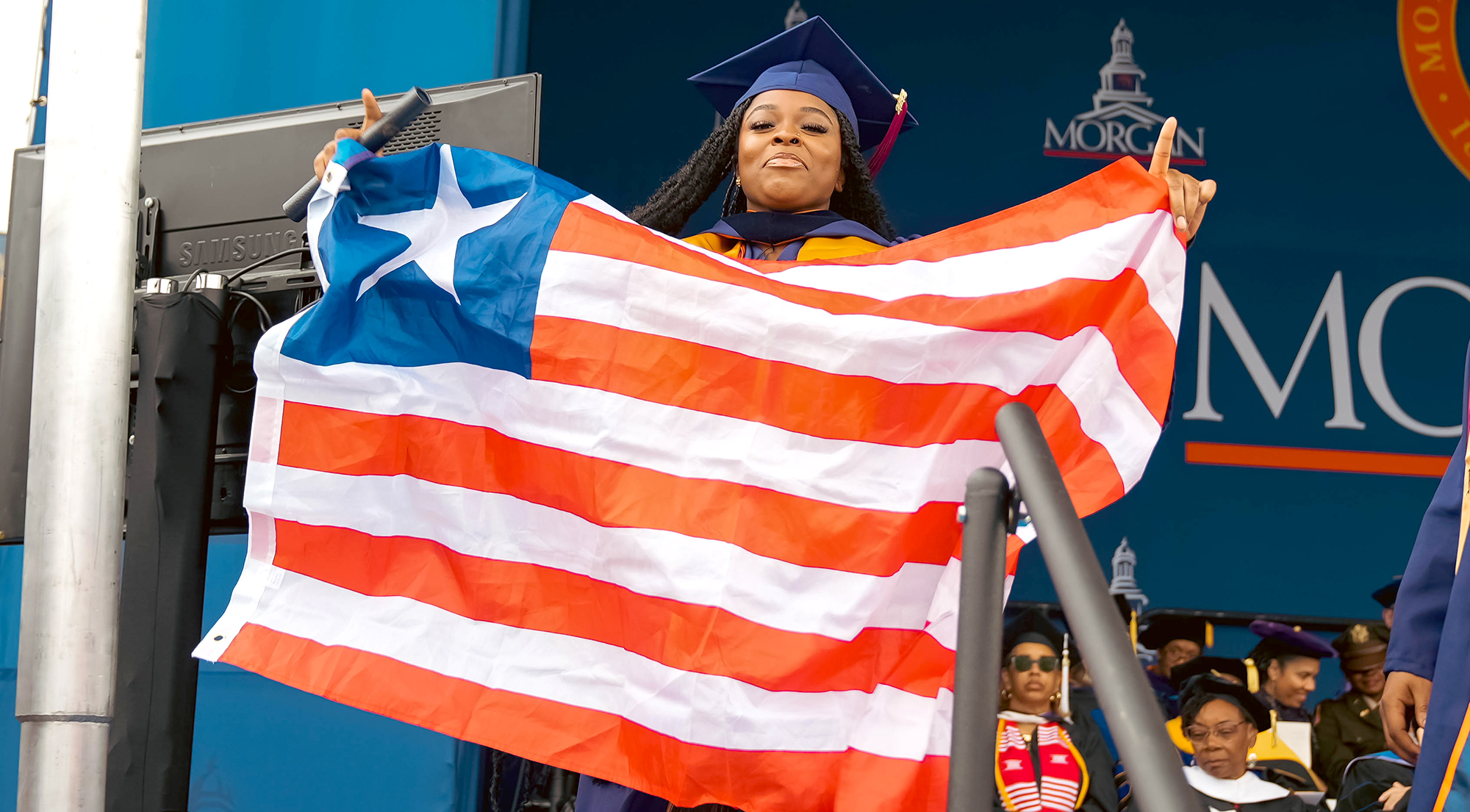Angel Smith, proudly presenting the Cuban flag, graduates at Morgan’s 2023 Spring Commencement, upon receiving a Bachelor of Science in Multi-Plaftorm Production from the School of Global Journalism and Communication.